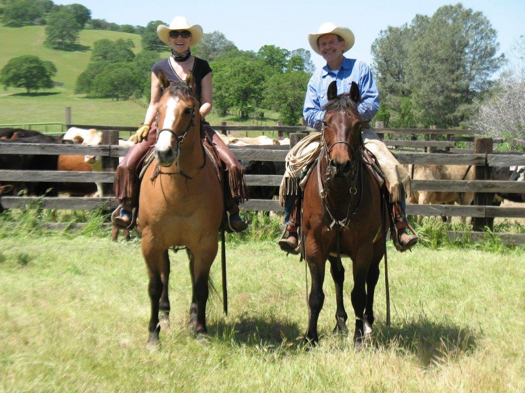 Larry Lalaguna riding a horse with cows in the background